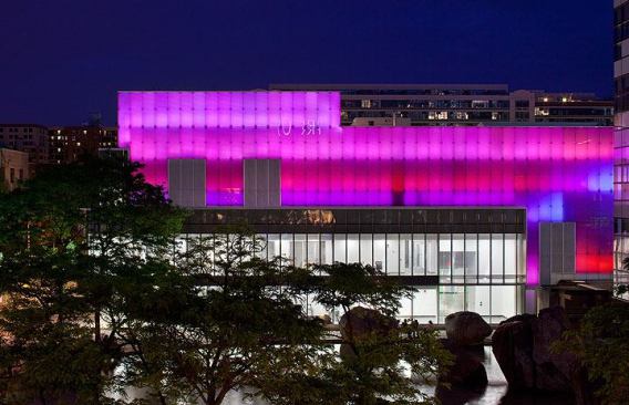 The façade bathed in magenta light.