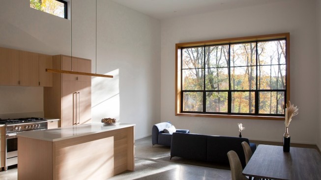 The focal point of the atrium space is a custom 10’ by 14’ steel window, strategically elevated to frame the treetops, wetlands, and distant mountain panorama.
