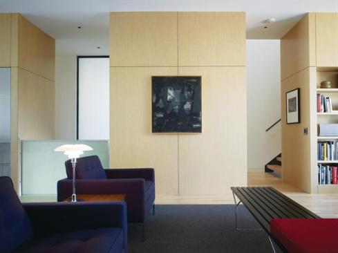 White oak millwork contains service and storage functions at all three floors.