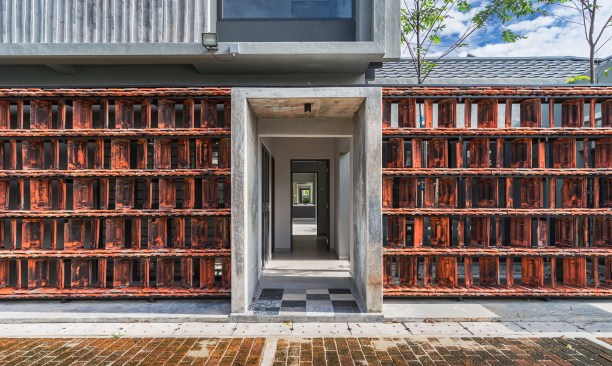 hand-crafted perforated wall constructed by the old roof tiles from the burnt house_