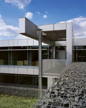 A steel-framed pavilion provides an outdoor sheltered terrace overlooking a restored wetland.