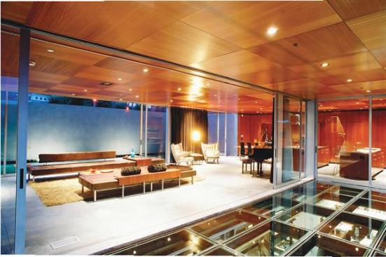First-floor living spaces spill out into protected courtyards, and onto a glass patio that roofs the owner's basement- level architecture studio.