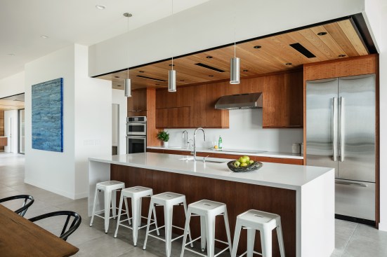 The floating cedar ceiling of the kitchen aligns with the entry ceiling beyond.  