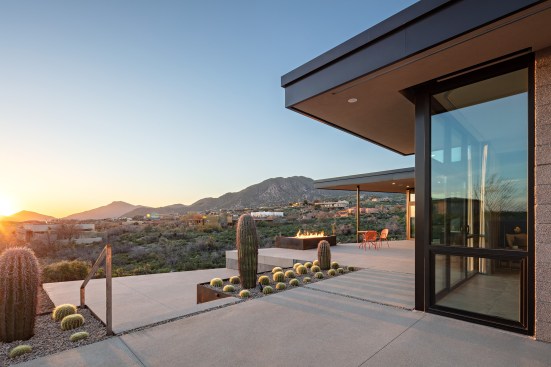 Raw steel planters are used to transition from upper patios to lower areas as the outdoor areas terrace down the hillside.