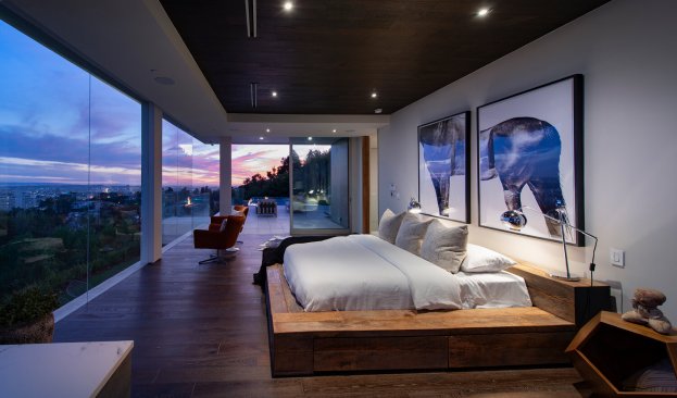 Luxury indoor outdoor living room with open sliding glass walls and penthouse style view.