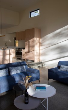 An operable overhead skylight and meticulously placed windows infuse the space with a sense of airiness, while satin-sheened polished concrete flooring with radiant heating create a cozy atmosphere throughout the living areas.
