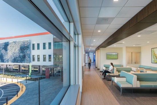 Full-height windows provide access to the outdoors and daylight at the waiting areas for positive distraction.