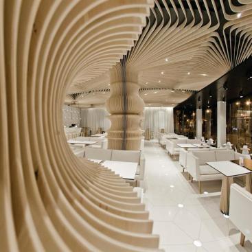 The slats that cover the columns and ceiling are replicated on the dining table bases.