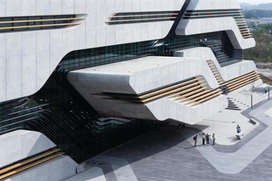 On+the+north+face+of+the+building%2c+the+projecting+volume+of+the+m%c3%a9diatheque+cantilevers+over+the+main+entrance.+The+paving+pattern+echoes+the+geometry+of+the+fa%c3%a7ade.