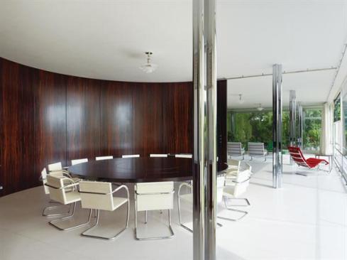 The+curved+Macassar+wood+wall+around+the+dining+area+returned+to+its+original+spot+in+the+house+(it+was+moved+during+the+1980+renovation)%2c+and+clad+in+a+new+veneer.+Now+the+sight+lines+through+the+living+area+and+into+the+conservatory+are+restored+to+Ludwig+Mies+van+der+Rohe%e2%80%99s+original+intent.