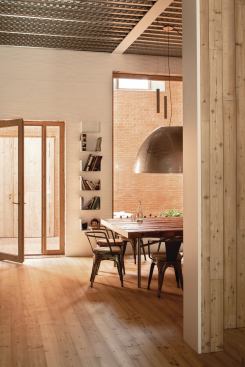 In the kitchen, shown here, and throughout the ground floor, the architects exposed the corrugated metal decking on the ceilings. The wood floor covers a concrete slab with radiant heating; the concrete slab of the second floor (above the decking) is laid with radiant heating as well.