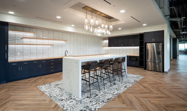 The kitchen has a residential feel with butcher block, rich blue cabinets, and an eclectic mix of metals.