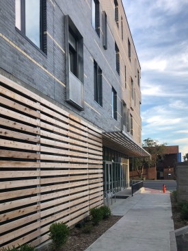 Though constructed of dark manganese ironspot brick, corner windows and a pattern of discontinuous light brick dashes wrapping the entire building lighten the brick mass visually over the more transparent ground level. Cedar screen walls and soffits add warmth to the lower level enhancing the pedestrian&nbsp;experience.