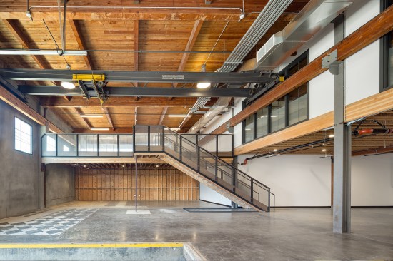 The project team kept features that pay tribute to the history of the building. An overhead crane, while no longer operational, is retained in a loading dock area. Suites on the four corners of the building offer mezzanines, one of which provides a view of a metal sign bearing the name "Milwaukee Mach. Co." on a rigging beam of one of the cranes.