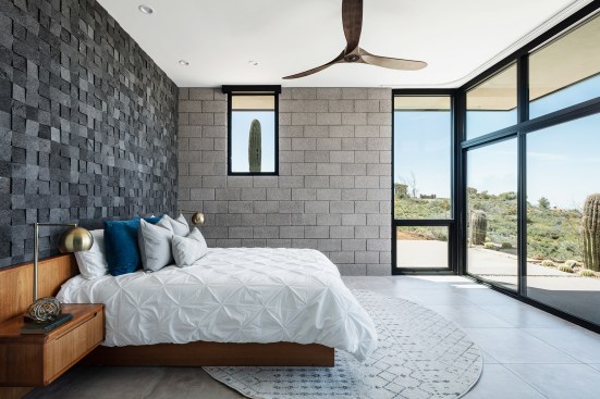 Master suite has views to the desert beyond.  Existing saguaro on centers on the smaller view at the exposed, bead blasted CMU wall.