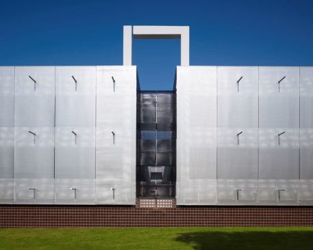 The garage's exterior is clad in a stainless-steel mesh. 'Outriggers' are added for architectural ornament and cast shadows on the fa??ade to create a layer of visual interest.