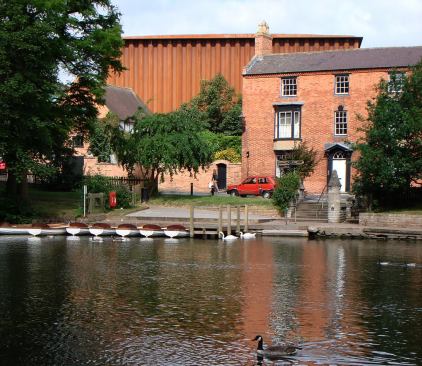The Courtyard Theatre-Stratford upon Avon, Warwickshire The Courtyard Theatre was designed as an extension to The Other Place, the Royal Shakespeare Company's 150-seat studio theater. The new theater has a new 1,050-seat auditorium, while the existing Other Place auditorium has been transformed into foyer spaces, cloakroom, bar areas, shop, booking office and call center, dressing rooms, and band rehearsal space. This new building has external walls built of Corten A steel sheets creating a sound-proof auditorium to meet the RSC's high acoustic requirements. This recyclable material was chosen for its no-maintenance surface and red color which blends with the surrounding buildings and the town. The interior of the walls is golden ply, and the red auditorium seating floats inside this box. The thrust-stage auditorium design is based on an original concept by the RSC. 
Architect: Ian Ritchie Architects