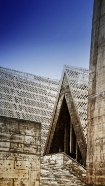 Perforated bronze skin and exposed concrete 