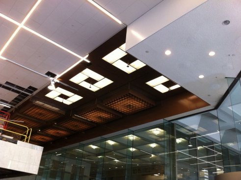 The new lighting (left) being installed in the ceiling; the old lighting (right) with its copper louvers.