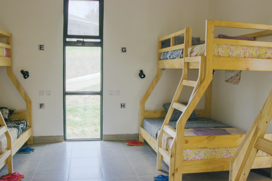 Dormitory rooms have four locally made bunk beds apiece; double mattresses on the lower bunks allow them to serve as couches during the day. 
