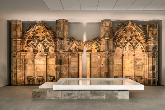 Entrance interior of the Church, featuring pieces of the remaining Gothic ruins in contrast with a custom modern baptismal font