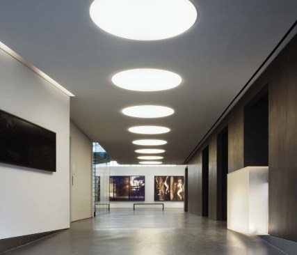 A 60-foot-long, dark anthrax-zinc wall leads visitors from the street to a double-height gallery at the rear of the