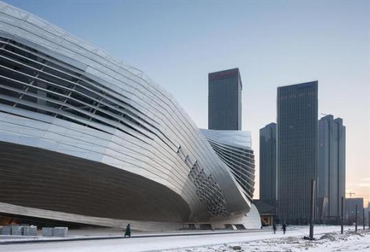 The+articulated+form+of+the+building+contrasts+sharply+with+the+orthogonal+towers+that+are+driving+the+expansion+across+much+of+Dalian%e2%80%99s+emerging+Central+Business+District.+Seen+as+the+central+architectural+piece+in+the+master+plan%2c+the+conference+center+is+surrounded+by+landscaping+and+will+stand+apart+from+the+density+of+the+rest+of+the+area.+