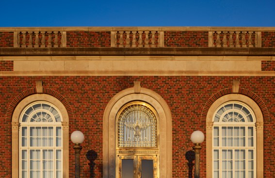 The+main+entrance+with+the+bronze+doors%2c+eagle+and+the+adjacent+arched+windows+are+shaded+from+the+inside+to+create+a+hint+of+the+new+contents.