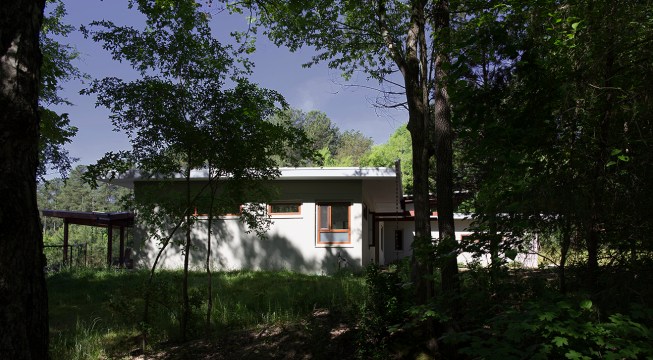 The first view of the house through the forest along the approach road.