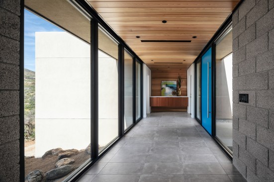 The entry ‘bridge’ is a thin strip of glass with a floating cedar ceiling that turns down at the far end to form the wall finish at the key drop area.