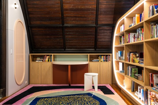 Librarian’s table next to main shelving unit with embedded LED lighting