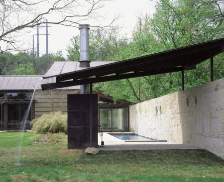 Though the house is just across Lake Austin from the city's downtown, the architects managed to preserve its rural feel. Another stone wall at the rear of the site makes a private outdoor room of the pool area and shields a neighboring property from view.