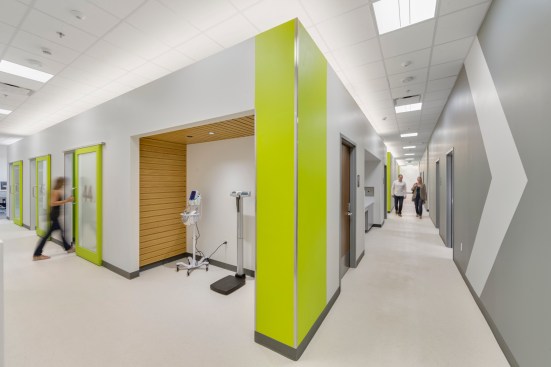 Color coded exam room pods and graphics assist with wayfinding for a diverse patient population.