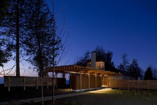 A series of wood columns extends the length of the slender building, supporting laminated wood beams and rafters.