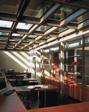 A basement-level home office receives light through a glass ceiling that doubles as the terraces floor.