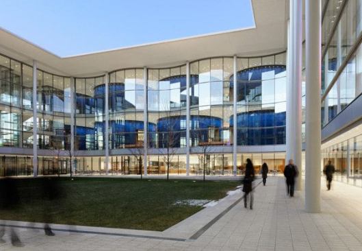 The building assembles the school’s formerly scattered facilities, which serve some 300 students, around a grassy little courtyard and under one deeply overhanging roof.