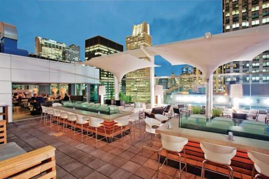 When the weather is warmer, patrons?hotel guests and locals alike?spill out onto the rooftop terrace, which features inverted umbrellas shielding bar-height countertops and perimeter tables and banquettes. Glass panels extend up to what would be ceiling height to help mitigate the high winds that can come off nearby Lake Michigan, without obstructing the view.