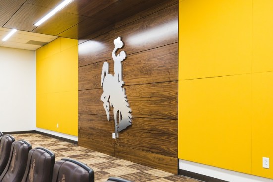 Bold brand graphics throughout player meeting rooms infuse the program’s culture and message into the space