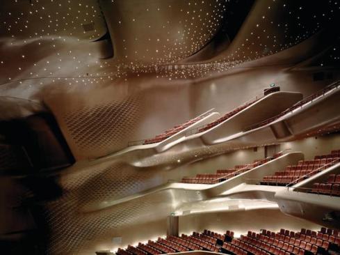 The smooth curving forms of the balconies in the main theater are formed from glass fiber-reinforced gypsum panels, cast in custom molds. The architects chose the material for its acoustic properties as well as its formability. The space, designed to showcase the varying tones of both Western and Chinese opera, has a reverberation time of 1.4 to 1.6 seconds.