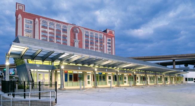 A 1984 mural by artist Richard Haas on the nearby Sheraton St. Louis City Center hotel overlooks the Gateway Transportation Center's north wing, which incorporates 10 canopied bays for Greyhound buses. The exterior is clad in zinc panels from Rheinzink, which can withstand the grit and chemicals that the highway overhead will shed onto the building.