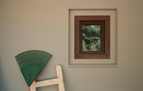 Nature is reflected in a small, wood-framed window.