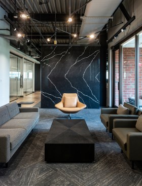 A monolithic marble wall is the only physical separation and creates a feature wall for the lounge area.