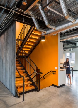 View of interior stair, lined in same steel angle at south façade, into fourth-floor kitchen