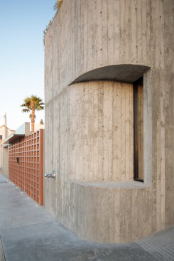 Carving into the curved concrete creates a nearly uninterrupted lower façade. 