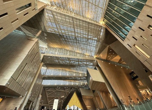 The open-air atrium is covered by a vast, light-filtering roof structure.
