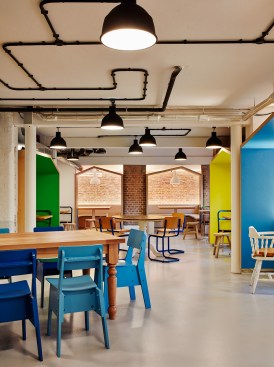 The lower-level canteen features a mix of eclectic style furnishings and light fixtures.