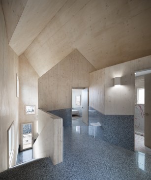 Looking southeast from the second-floor landing, one can see into the second bedroom at left, and the bathroom at right, which is lined with Ornamenta Artwork tile on the floor and walls. 