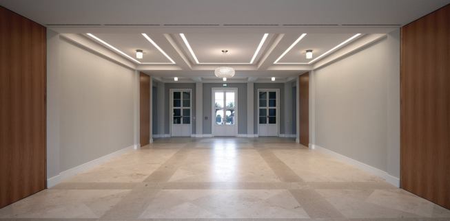 Much of the schloss has been recast as a conference center, and the interiors combine classical proportions with modern finishes. The old foyer can be subdivided for smaller meetings and seminars; the space is paved in Jura limestone and opens out to the gardens. Conference attendees enter through a different entrance than that of the museum, which occupies the main level in the building’s east and west wings. 