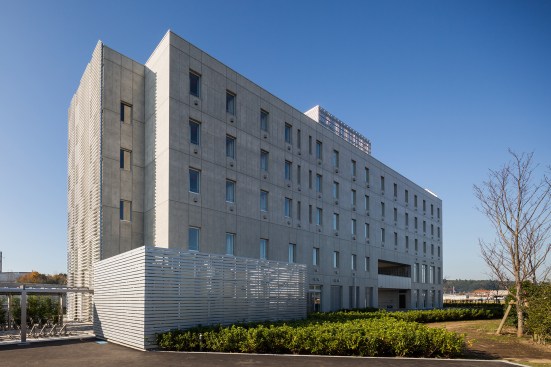 Dorm rooms line the building’s northeast side, providing views of rice fields beyond.