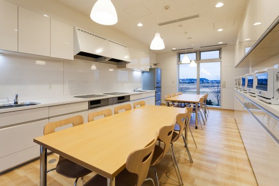 A group kitchen on the second floor sits adjacent to a common room and terrace.